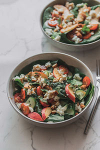 High angle view of salad in bowl on white marble table