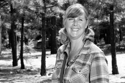 Portrait of smiling woman against trees