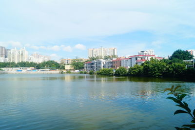 Buildings by sea against sky in city