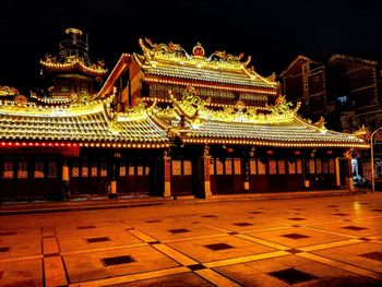 Illuminated temple building against sky at night