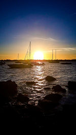 Silhouette sailboat on sea against sky during sunset