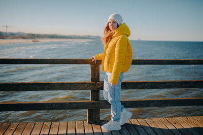 Rear view of woman standing by railing