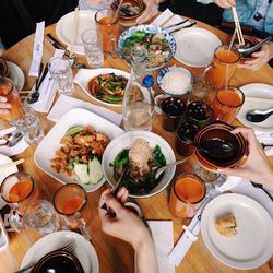 Cropped image of woman serving food at dining table