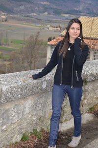 Full length of young woman looking away while standing on observation point