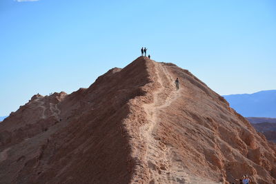 Low angle view of people hiking on mountain