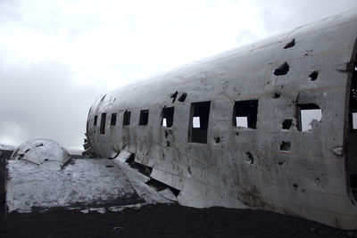 Abandoned airplane against sky