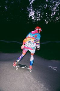 Rear view of woman with umbrella on road