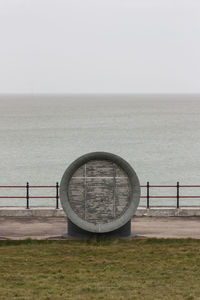 View of railing by sea against clear sky