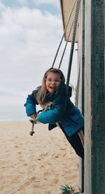 Portrait of smiling young woman on land against sky