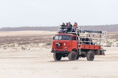 People on desert against clear sky