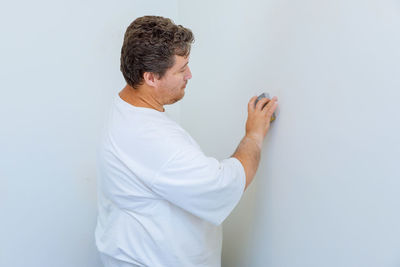 Side view of man looking away against white background