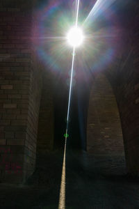 Sunlight streaming through illuminated street in city