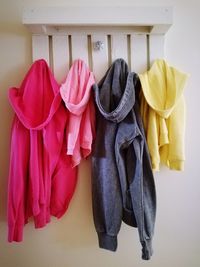 Close-up of hooded jackets hanging on hooks at home