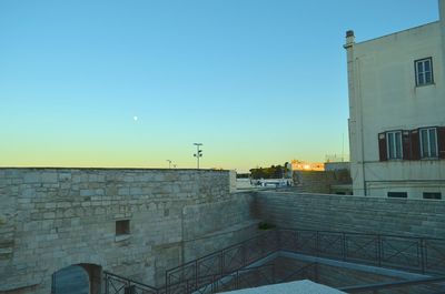 Buildings against clear blue sky at dusk