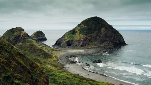 Scenic view of sea and mountains against sky