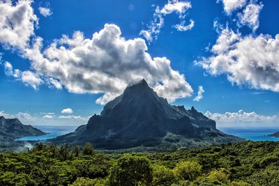 Scenic view of mountains against blue sky