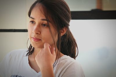 Close-up of thoughtful young woman looking away at home 