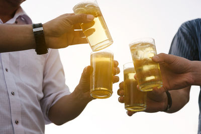 Midsection of man holding beer glass