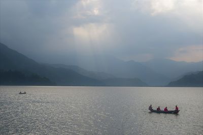 Scenic view of sea and mountains against sky