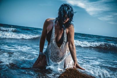 Woman at beach against sky