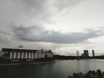 Bridge over river against buildings in city