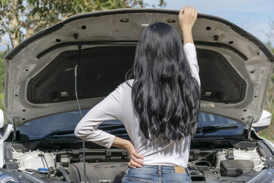 Rear view of woman standing in car