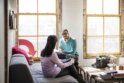 Businessman explaining female colleague in creative office