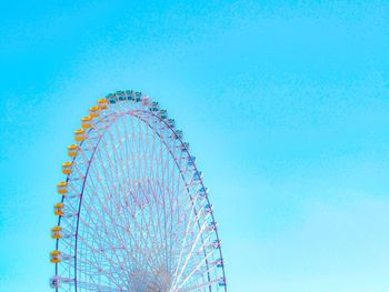 Low angle view of ferris wheel against blue sky