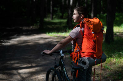 Full length of woman with bicycle standing on land