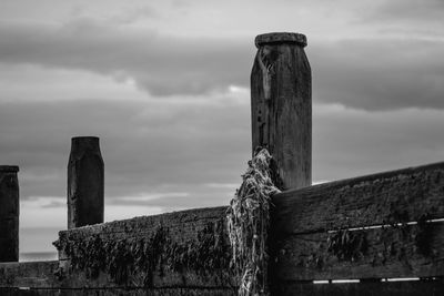 Low angle view of wooden post against sky