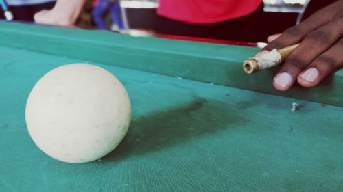 Close-up of hand holding ball on table