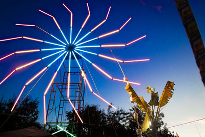 Low angle view of illuminated lights against sky at night