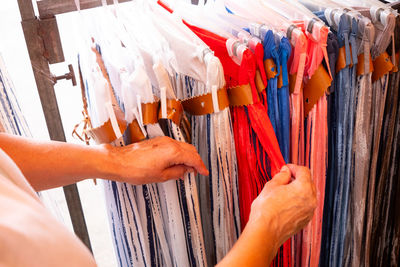 Midsection of man choosing textile in store