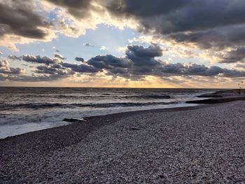 Scenic view of beach against sky during sunset