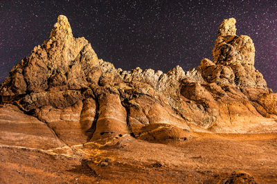 Rock formations on landscape against sky at night