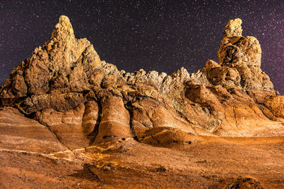 Rock formations on landscape against sky at night