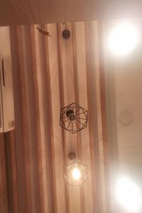 Low angle view of illuminated pendant light hanging from ceiling