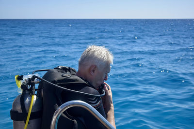Diving lesson in open water. male in scuba diving suit is preparing to dive into deep sea.