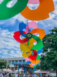 Low angle view of multi colored balloons hanging against sky