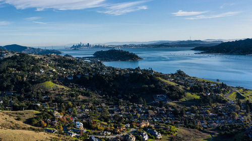 Aerial view of city by sea against sky