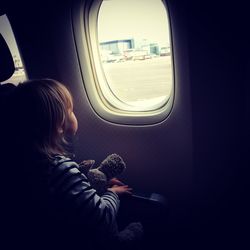 Rear view of boy sitting in airplane
