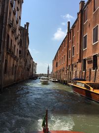 Boats moored in canal along buildings