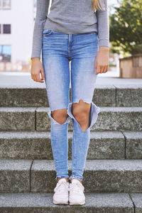 Low section of woman standing on staircase