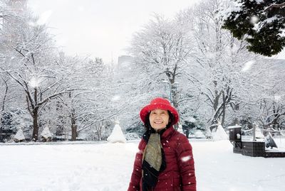 Portrait of smiling woman standing in snow