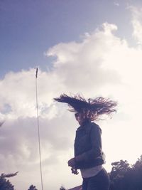 Low angle view of woman standing against sky