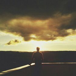 Silhouette of woman against cloudy sky