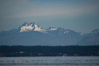 Scenic view of snowcapped mountains by lake against sky