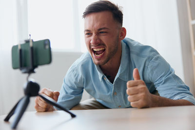 Cheerful young man vlogging with smart phone