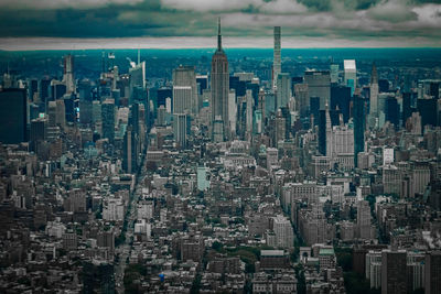 Aerial view of buildings in city against sky