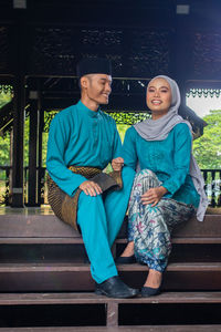 Portrait of smiling couple sitting on seat